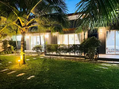 a house with a palm tree in the yard at Marisa Garden Bungalow in Bang Tao Beach