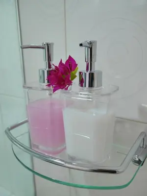 a glass shelf with a faucet and a pink flower on it at Marisa Garden Bungalow in Bang Tao Beach