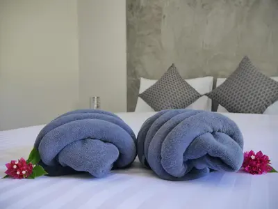 two towels are sitting on top of a bed at Marisa Garden Bungalow in Bang Tao Beach