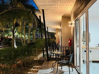 a patio with a table and chairs next to a pool at Marisa Garden Bungalow in Bang Tao Beach