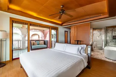 a bedroom with a bed and a bath tub at Centara Grand Beach Resort Phuket in Karon Beach