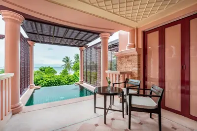 a patio with a table and chairs and a swimming pool at Centara Grand Beach Resort Phuket in Karon Beach