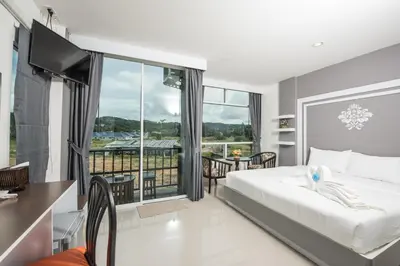 a hotel room with a bed and a balcony at Vacation Time House in Nai Yang Beach
