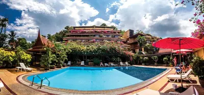 a hotel with a swimming pool in front of a building at Bougainvillea Terrace House in Kata Beach