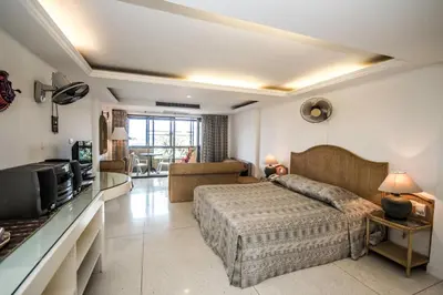 a bedroom with a bed and a tv in a room at Bougainvillea Terrace House in Kata Beach