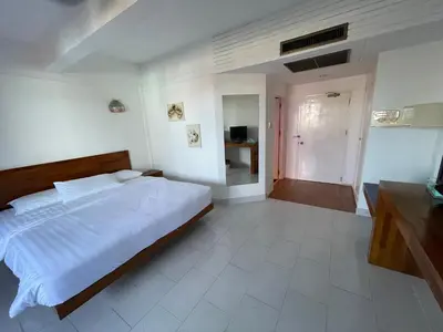 a bedroom with a large white bed and a hallway at Bougainvillea Terrace House in Kata Beach