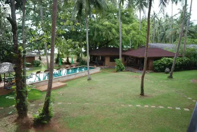 a resort yard with a swimming pool and trees at Melina Beach Front Bungalows in Tha Lane Bay