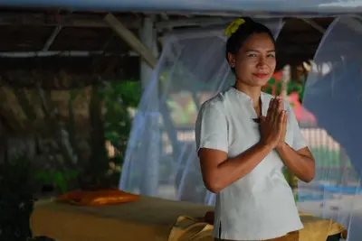 a woman standing with her hands clasped at Melina Beach Front Bungalows in Tha Lane Bay