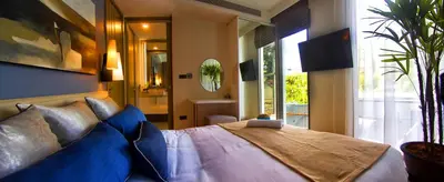 a bedroom with a large bed with blue pillows at Oceanstone by Holy Cow, 2-BR, 60 m2, tree view in Bang Tao Beach