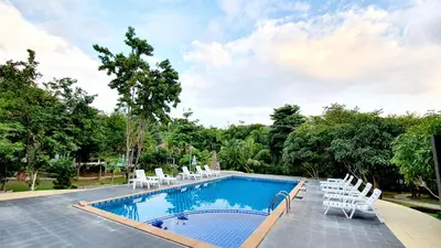 a swimming pool with white lounge chairs and a swimming pool at Supsangdao Resort in Ao Nang Beach