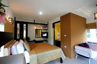 a bedroom with a bed and a chair and a television at Supsangdao Resort in Ao Nang Beach