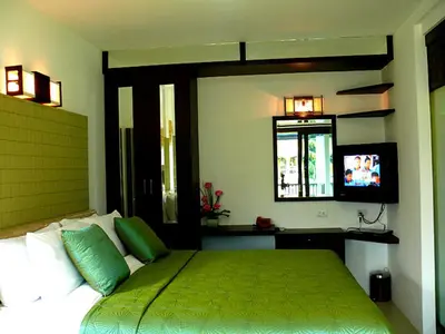 a bedroom with a green bed and a television at Supsangdao Resort in Ao Nang Beach