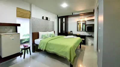 a bedroom with a bed with a green blanket at Supsangdao Resort in Ao Nang Beach