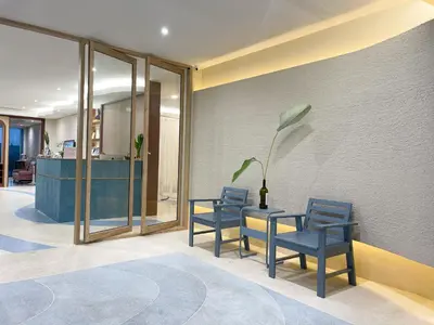 a lobby with two blue chairs and a table at Ben's House in Ao Nang Beach
