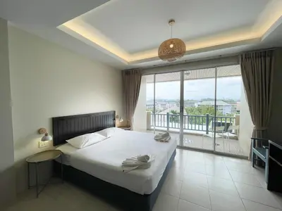 a bedroom with a bed and a large window at Ben's House in Ao Nang Beach