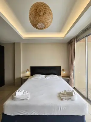 a bedroom with a white bed with two towels on it at Ben's House in Ao Nang Beach