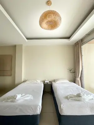two beds in a hotel room with a ceiling at Ben's House in Ao Nang Beach
