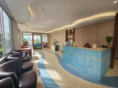 a lobby with a waiting room with leather chairs and a counter at Ben's House in Ao Nang Beach