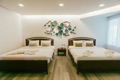 a bedroom with two beds and a wreath on the wall at Phranang Place- SHA Extra in Ao Nang Beach