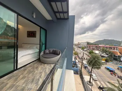 a balcony with a bed and a view of a city at Phranang Place- SHA Extra in Ao Nang Beach