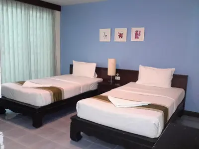 two beds in a room with blue walls at J Hotel in Ao Nang Beach