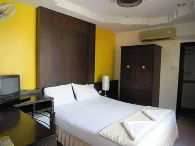 a bedroom with a bed and a desk and a television at J Hotel in Ao Nang Beach