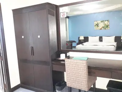 a bedroom with a mirror and a dresser and a bed at J Hotel in Ao Nang Beach