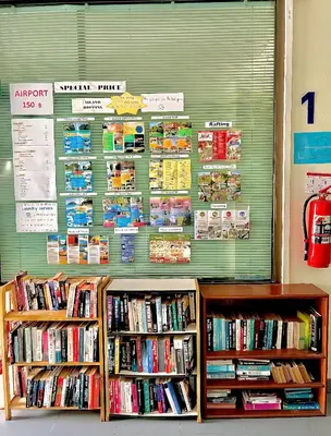 a library with two shelves of books at J Hotel in Ao Nang Beach