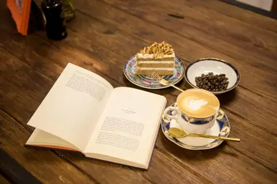 a book and a cup of coffee and a piece of cake at The Neighbors Hostel in Phuket Town