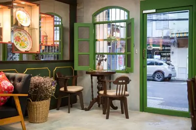 a restaurant with a table and chairs and a window at The Neighbors Hostel in Phuket Town