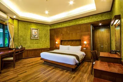 a bedroom with a bed and a table and a desk at Naiyang Park Resort - SHA Extra Plus in Nai Yang Beach