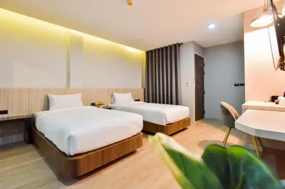 a hotel room with two beds and a desk at U Rip Resort Phi Phi Hotel in Phi Phi Don