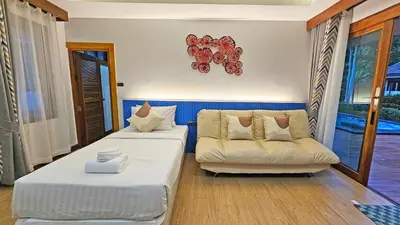 a living room with two beds and a couch at U Rip Resort Phi Phi Hotel in Phi Phi Don