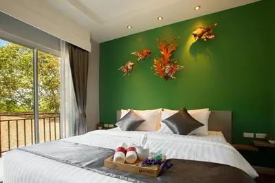 a bedroom with a large bed with a green wall at U Rip Resort Phi Phi Hotel in Phi Phi Don