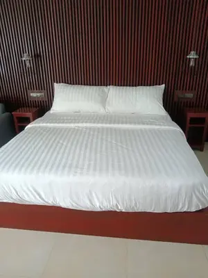 a bed with white sheets and pillows in a room at Beach house by Rose massage in Nai Thon Beach