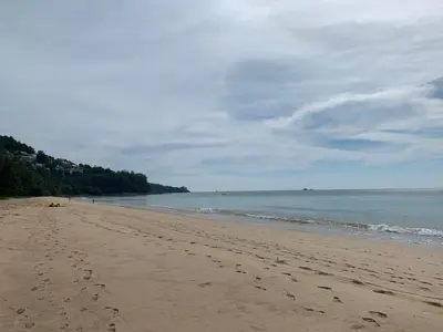 a beach with footprints in the sand and the ocean at Beach house by Rose massage in Nai Thon Beach
