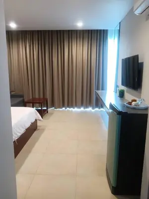 a hotel room with a bed and a television at Beach house by Rose massage in Nai Thon Beach