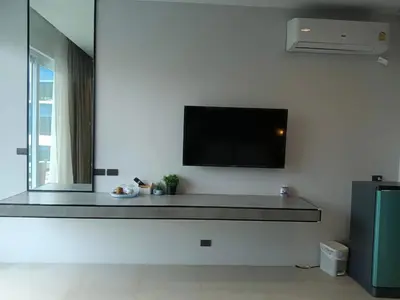 a living room with a flat screen tv on a wall at Beach house by Rose massage in Nai Thon Beach