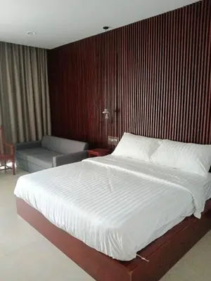 a bedroom with a large white bed and a chair at Beach house by Rose massage in Nai Thon Beach