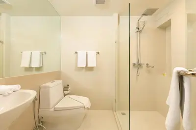 a bathroom with a shower and a toilet and a sink at The Aristo by Holy Cow, 4-BR loft, 150 m2, pool view in Surin Beach