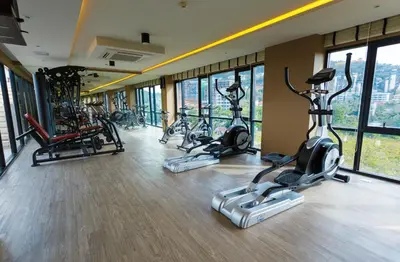 a gym with several exercise bikes in a room with windows at The Aristo by Holy Cow, 4-BR loft, 150 m2, pool view in Surin Beach