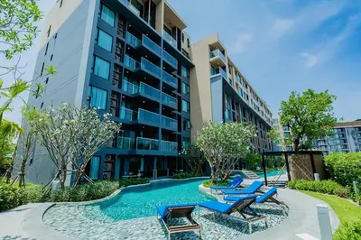 a swimming pool with lounge chairs in front of a building at The Aristo by Holy Cow, 4-BR loft, 150 m2, pool view in Surin Beach