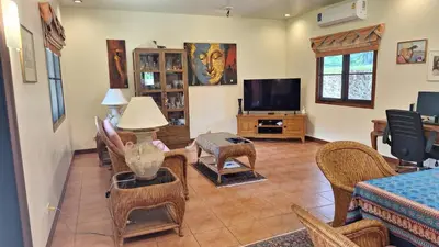 a living room filled with furniture and a flat screen tv at Villa Pimlada in Nai Harn Beach