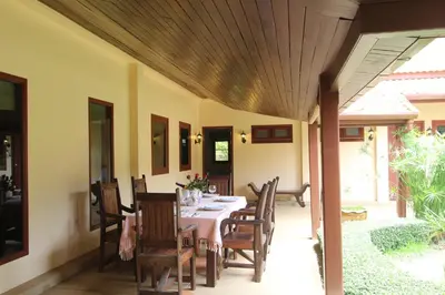 a dining room with a table and chairs at Villa Pimlada in Nai Harn Beach