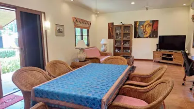 a living room with a table and chairs at Villa Pimlada in Nai Harn Beach