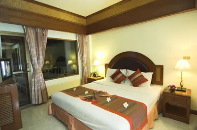a hotel room with a large bed and a window at PS Hotel Phuket Patong - SHA Plus in Patong Beach