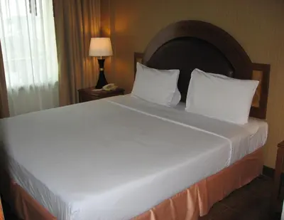 a bed with white sheets and pillows in a hotel room at PS Hotel Phuket Patong - SHA Plus in Patong Beach