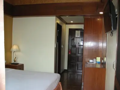 a bedroom with a bed and a wooden door at PS Hotel Phuket Patong - SHA Plus in Patong Beach