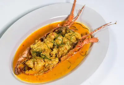 a plate of food with a shrimp in a yellow sauce at PS Hotel Phuket Patong - SHA Plus in Patong Beach