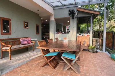 a wooden table and chairs on a patio at Baleeyan in Thalang